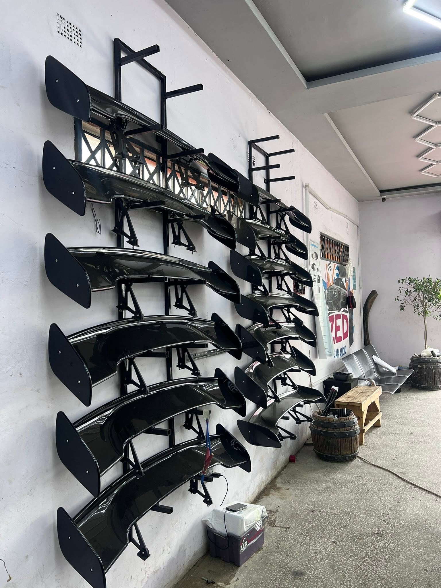 Wall of body kit spoilers and wings in the ZED workshop